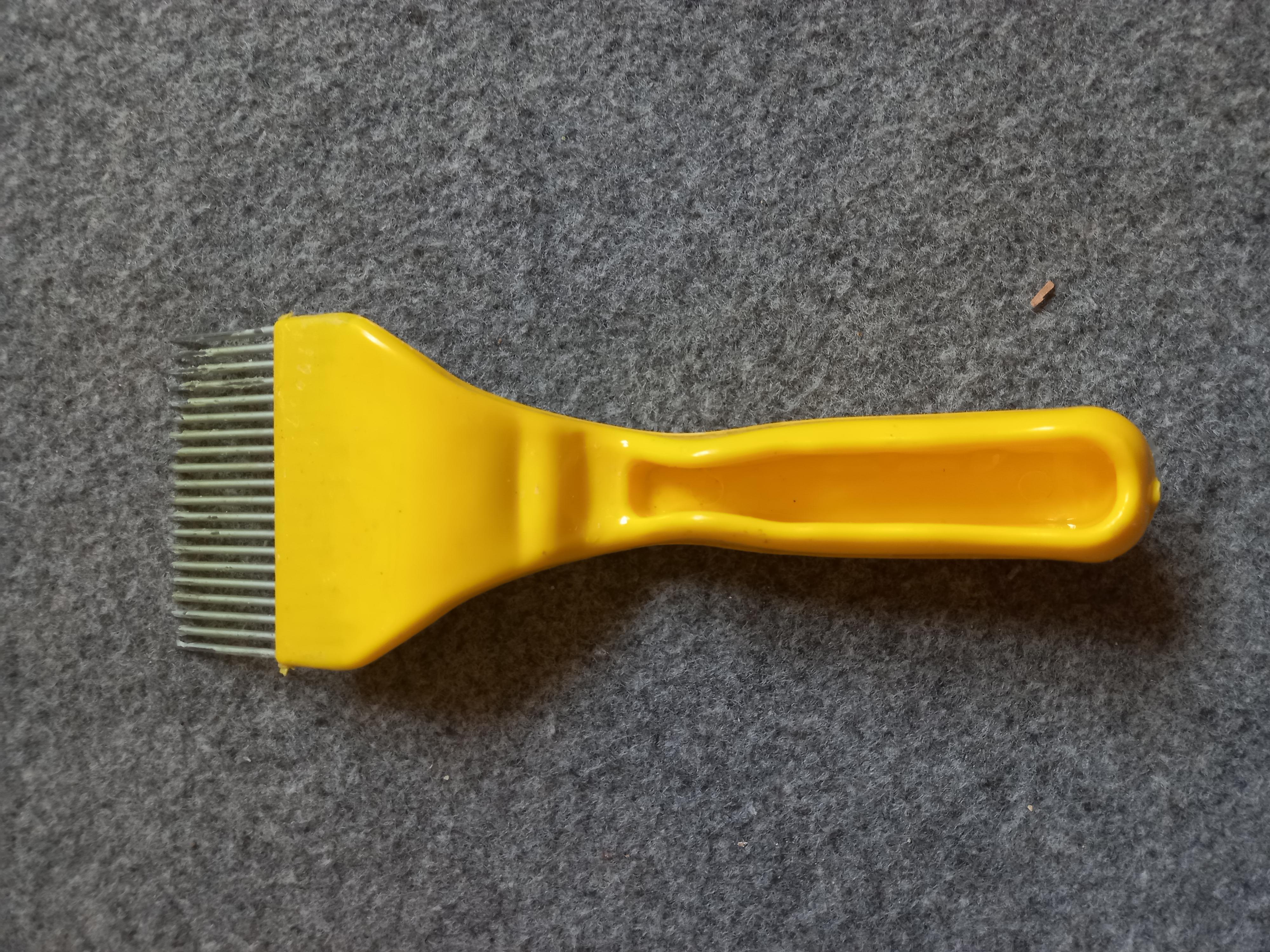 Honeycomb uncapping brush in Ghana